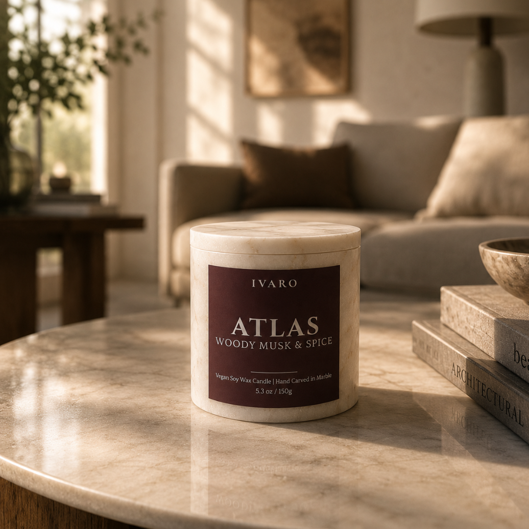 IVARO Atlas candle on a marble table in a living room setting. Woody musk soy wax candle by IVARO bringing depth, warmth and sophistication to modern homes